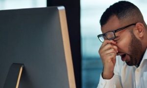 Shot of a young businessman experiencing stress during late night at work